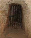 Iron gate across the tunnel with rubbish on the other side of it